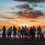 people standing on shore during golden hour